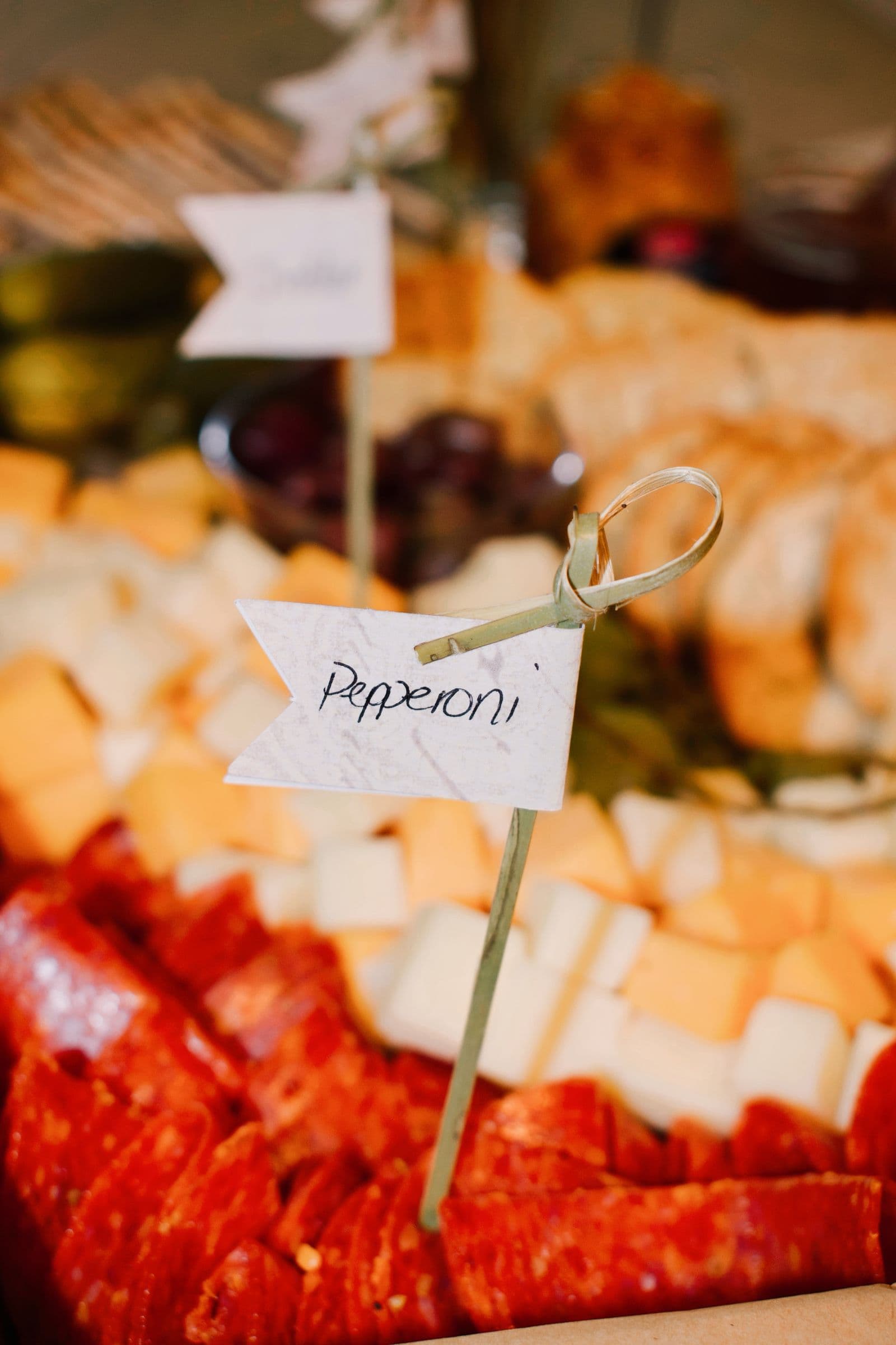 Close-up of a charcuterie platter with small labeled tags identifying each item