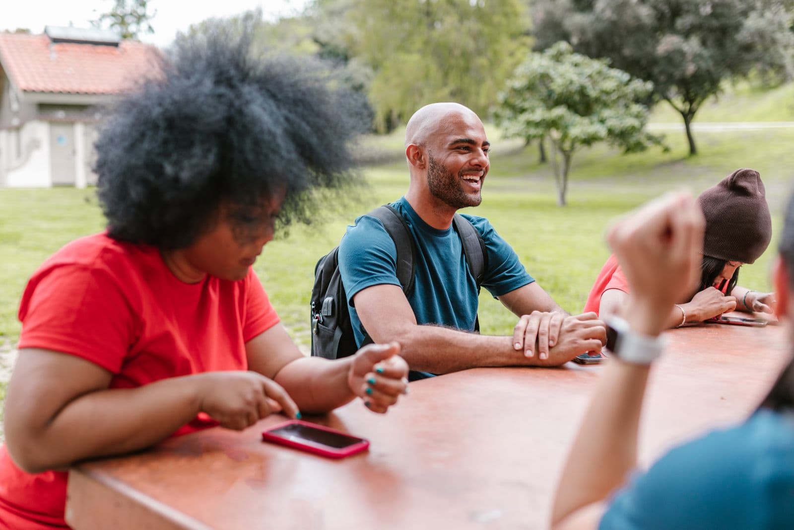 A group of coworkers relaxing and bonding together outdoors in a sunny park