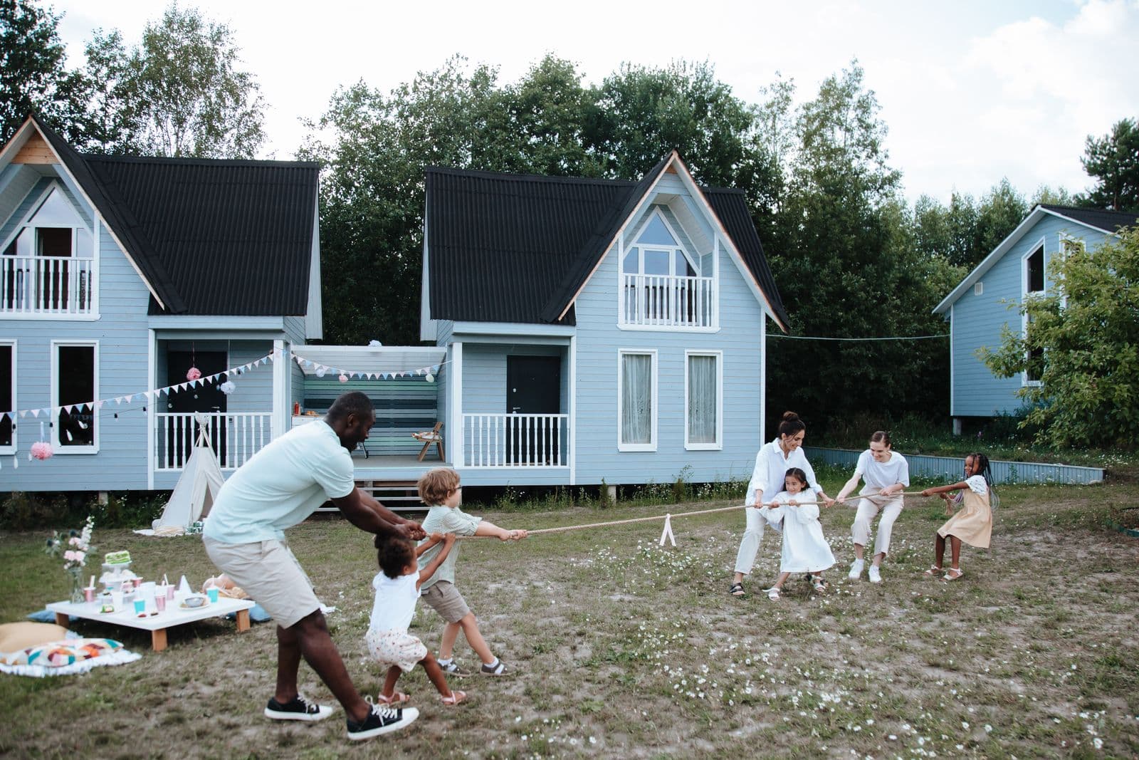 A diverse multigenerational family playing tug of war together outdoors on a sunny day